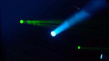 Bir ışık dizisi karanlık bir ortamdan geçişleri aydınlatır, mavi ve yeşil renkleri vurgulayarak büyüleyici bir görsel etki yaratır ve atmosferi güçlendirir.