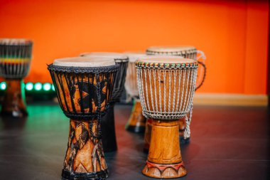 Renkli bir ortamda sergilenen geleneksel Afrika davulları koleksiyonu, eşsiz oymalar ve dokular, kültürel ve müzikal temalar için mükemmel