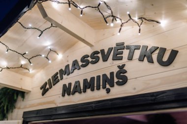 Valmiera, Letonya - 30 Kasım 2025 Ziemassvetku Namins tabelalarının yer aldığı şenlikli ahşap yapı sıcak bir ortam yaratıyor.