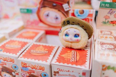 Dubai, Birleşik Arap Emirlikleri - 13 Ocak 2026: Canlı bir perakende ortamında dekoratif kutular üzerine yerleştirilmiş renkli yüzü ve şapkası olan sevimli peluş oyuncak