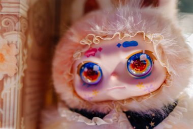 Dubai, Birleşik Arap Emirlikleri - 13 Ocak 2026: Canlı gözlü ve tavşan kostümlü bir oyuncak bebek, çiçek desenli bir arka planda, karmaşık detaylarla hazırlandı