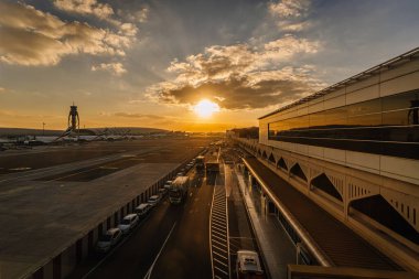 Dubai, Birleşik Arap Emirlikleri - 18 Ocak 2026: Dubai DBX havaalanı, günbatımının altın ışığını yansıtan modern mimari ile pistte araçlara sahiptir.