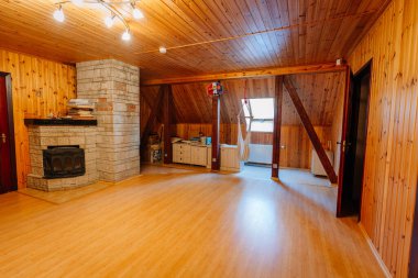 Kuldiga, Letonya - 30 Ocak 2026: Ahşap duvarları ve döşemeleri olan, taş şömine ve geniş pencereli, doğal ışığa izin veren konforlu oda