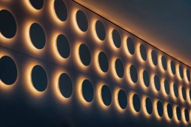 Dubai, Birleşik Arap Emirlikleri - 18 Ocak 2026: Dairesel aynalarla çevrili çağdaş duvar şık bir iç dekorda sıcak ışıkla çevrili