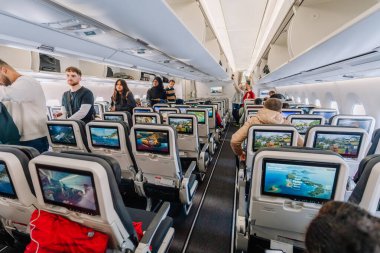 Dubai, Birleşik Arap Emirlikleri - 18 Ocak 2026: Yolcularla dolu modern uçak kamarası, her koltukta ve üst bölmelerde kişisel eğlence ekranları yer alıyor
