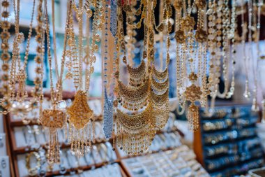 Dubai, Birleşik Arap Emirlikleri - 13 Ocak 2026: Dubai Global Village 'daki bir pazar yerinde altın kolye ve zincirler asılı, ayrıntılı işçilik ve çeşitliliği vurgulanıyor