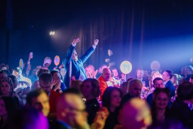 Riga, Letonya - 30 Ocak 2026: Şeker Diyarı. Katılımcılar canlı ışıklandırmayla, içkilerle süslenmiş masalarla ve numaralandırılmış tabelalarla dolu bir etkinliğin keyfini çıkarıyorlar.