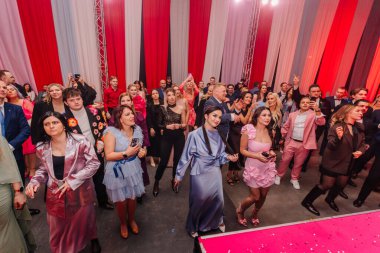 Riga, Letonya - 30 Ocak 2026: Şeker Diyarı. Çeşitli insanlar renkli perdeleri ve parlak ışıklarıyla neşeli bir atmosfer yaratan neşeli bir etkinliğin keyfini çıkarıyorlar.