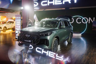Riga, Letonya - 4 Şubat 2026: Chery. Chery TIGGO 8 SUV, arka planda parlak ışıklandırma ve promosyon markalaşması olan bir sergide sergilendi