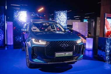 Riga, Letonya - 4 Şubat 2026: Chery. Chery TIGGO 7 Pro CSH modeli renkli ışıklandırma ve çağdaş görüntü elementlerinin yer aldığı bir marka sunumunda sergilendi