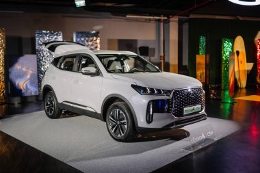 Riga, Letonya - 4 Şubat 2026: Chery. Chery TIGGO SUV arka planda canlı ışıklandırma ve dekoratif unsurlarla bir marka tanıtım etkinliğinde sergilendi
