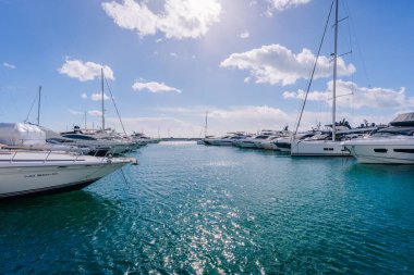 Marbella, İspanya - 13 Şubat 2026: Lüks yatlar berrak turkuaz suyu ve parlak gökyüzü olan bir marinaya demirlediler ve güzel bir kıyı manzarası yarattılar.