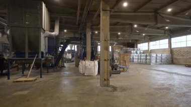 Cesis, Letonya - 21 Kasım 2025: Geri dönüştürülmüş kağıttan selüloz yalıtımı üreten sanayi tesisi, iyi aydınlatılmış bir ortamda makine ve malzemeler sergileniyor