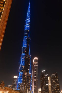 Dubai, Birleşik Arap Emirlikleri - 14 Ocak 2026: Burj Halife, dünyanın en yüksek binası, geceleri mavi ışıklarla parlar, diğer gökdelenlerle çevrilidir.