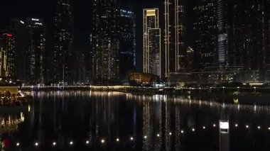 Dubai, Birleşik Arap Emirlikleri - 14 Ocak 2026: Dubai 'nin gece gökdelenleri, suyu aydınlatan gökdelenler, canlı bir kentsel atmosfer yarattı