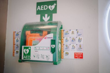 İstanbul, Türkiye - 18 Ocak 2026: Otomatik dış defibrilatör (AED), ilk yardım talimatları ve acil durum iletişim bilgileriyle birlikte duvarda sergilendi