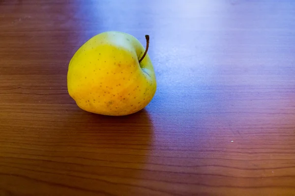 Manzana amarilla en el escritorio — Foto de Stock