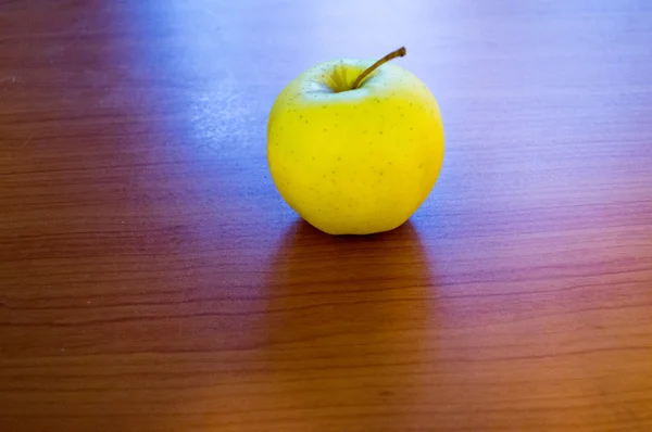 Manzana amarilla en el escritorio — Foto de Stock