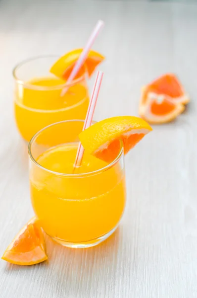 Some orange juice with straw into glass for breakfas