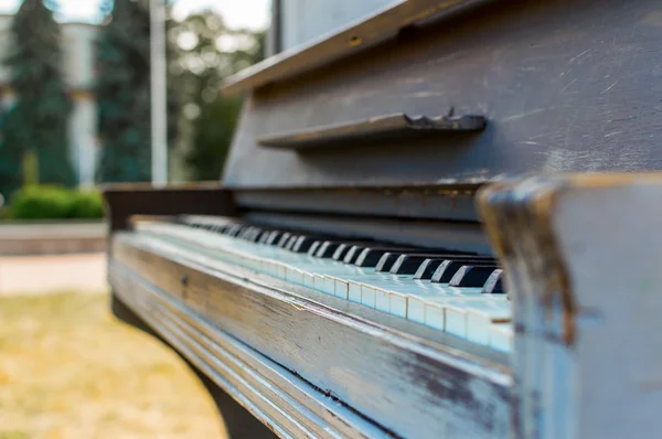 Old piano painted in blue color on the street