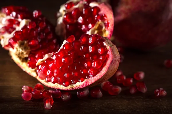 Sulu kırmızı nar tohumları üzerinde ahşap masa ile
