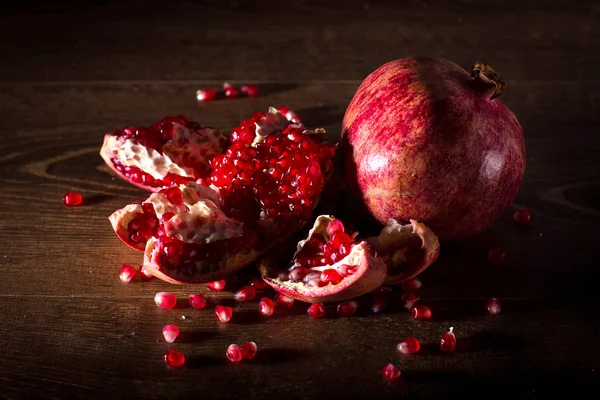 Sulu kırmızı nar tohumları üzerinde ahşap masa ile