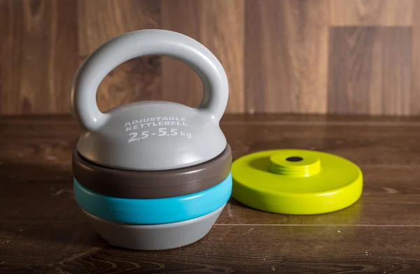 Ahşap arka plan üzerinde ayarlanabilir kettlebell. Bir fitness eğitimi için ağırlıklar.