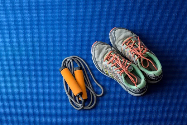 Spor ayakkabı, mavi yoga mat zemin üzerine ip atlama