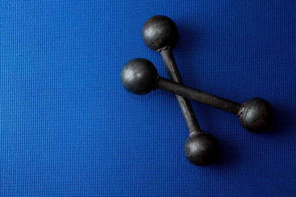 Retro Iron Grunge Hanteln auf blauem Yogamatte Hintergrund — Stockfoto