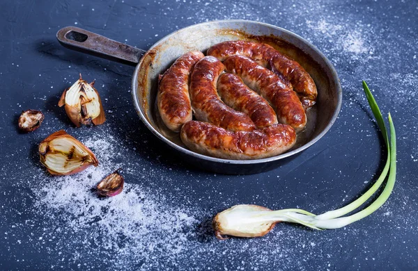 Ülke stil sosis ızgara ve taze sebze karanlık bir arka plan ile bir tavada fırında. Lezzetli ve taze.