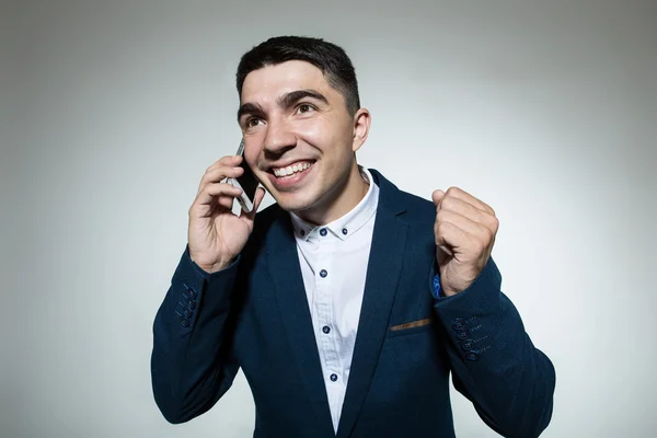 Genç işadamı yanıtlama akıllı telefon gülümseyen.