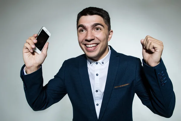 Çığlık ve yumruklarını gösterilen telefon ile mutlu bir adam portresi.