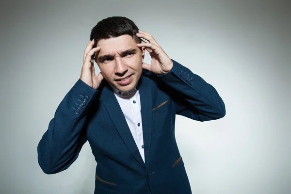Genç işadamı her iki iki eliyle tutarak bir baş ağrısı kafasına eller