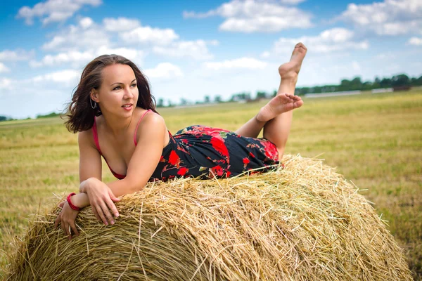 Girl on hay, round haystack, from the village, field — Stock Photo, Image