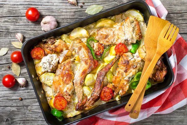 Kaninchenfleisch gebacken mit saurer Sahne und Tomaten, Paprika, Knoblauch, — Stockfoto