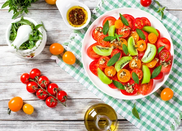 Помідор, ківіфрут і м'ятний салат з пляшкою оливкової олії — стокове фото