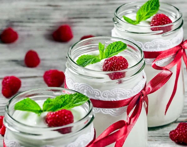 Leckerer Joghurt mit Himbeeren und Minze im Glas, selektiv — Stockfoto