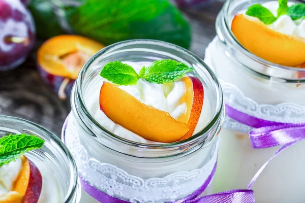 Yoghurt met rijpe pruimen en munt in een glazen potten — Stockfoto