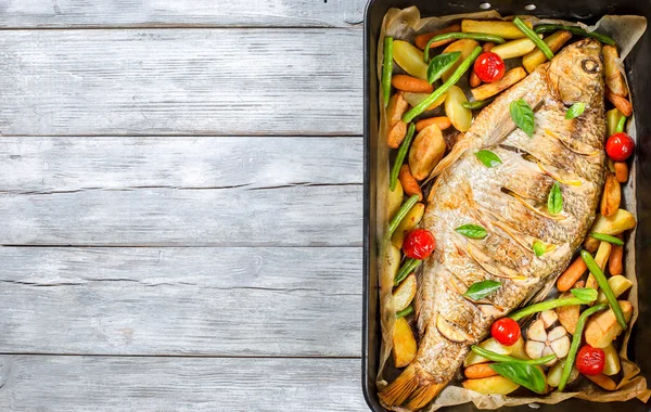 Pescado entero horneado en una bandeja para hornear, vista superior — Foto de Stock