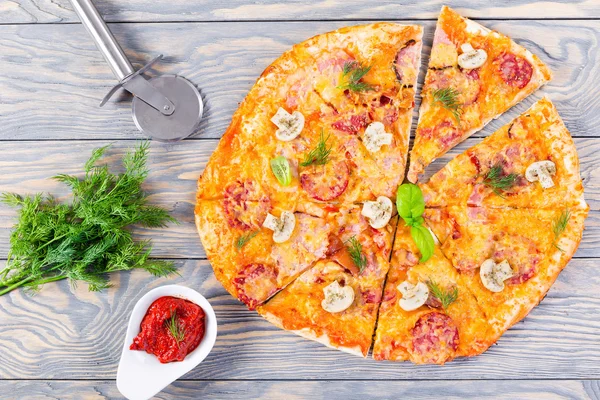 Pizza con salchichas, jamón, champiñones y queso, vista desde arriba — Foto de Stock