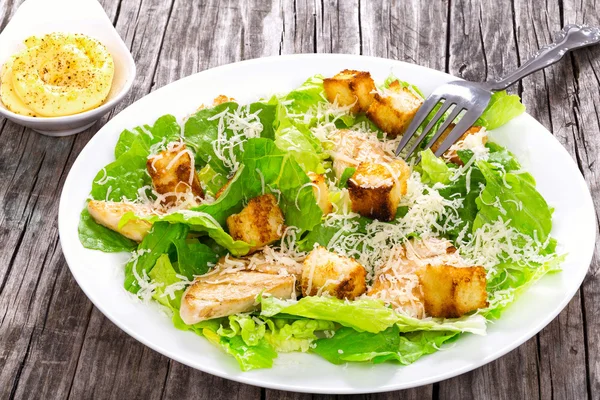 Caesar Salad with grilled chicken on a white plate, close-up — Stock Photo, Image