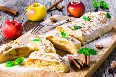 baked homemade apple strudel with powdered sugar and mint leaves clipart