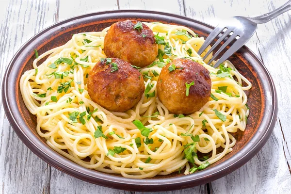 Makaron spaghetti z klopsikami, posypane posiekaną natką pietruszki, widok z góry — Zdjęcie stockowe