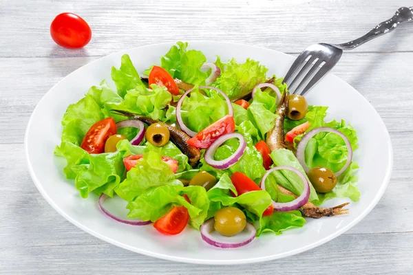 Вишневі помідори, червона цибуля, зелені оливки, листя салату, копчені щаблі — стокове фото