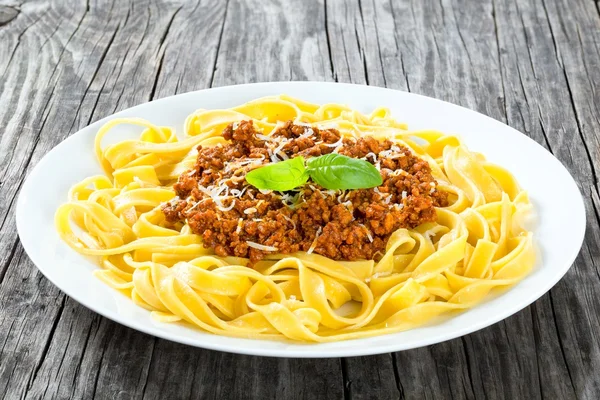 Ragú boloñés con pasta italiana en un plato blanco, primer plano — Foto de Stock