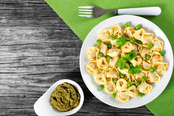 Tortellini with green peas, fried Pine nuts,  top view — Stock Photo, Image