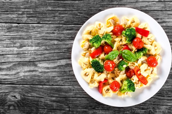 Tortellini med grillade körsbärstomater, broccoli, röd paprika, topputsikt — Stockfoto