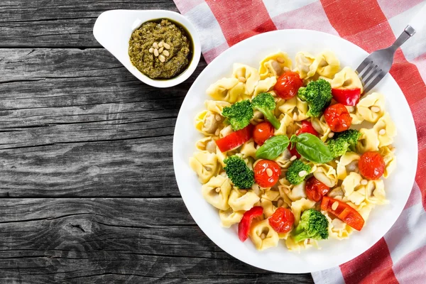 Tortellini with grilled cherry tomatoes, broccoli, red bell pepper, top view — Stock Photo, Image