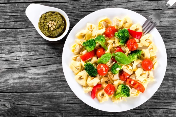 Tortellini with grilled cherry tomatoes, broccoli, red bell pepper, top view — Stock Photo, Image
