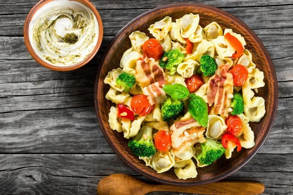 Tortellini with grilled cherry tomatoes, broccoli, red bell pepper, top view — Stock Photo, Image